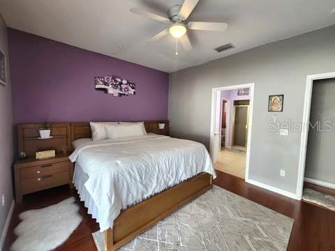 bedroom with hardwood / wood-style flooring, ceiling fan, and ensuite bathroom