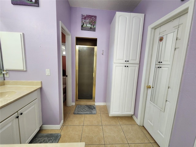 bathroom with vanity, toilet, tile patterned floors, and a shower with shower door