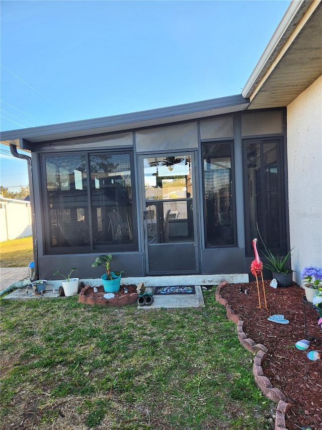 view of exterior entry featuring a lawn