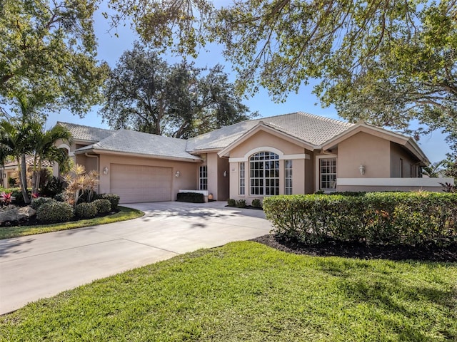 single story home with a garage and a front lawn