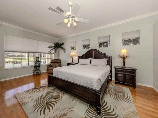 bedroom with crown molding, light hardwood / wood-style flooring, and ceiling fan