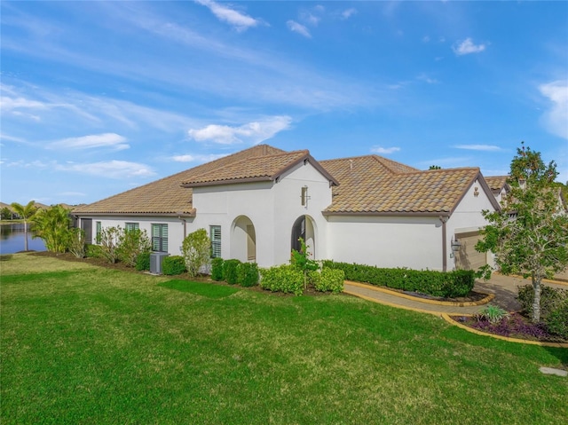 view of front of home featuring a garage, a front yard, and a water view