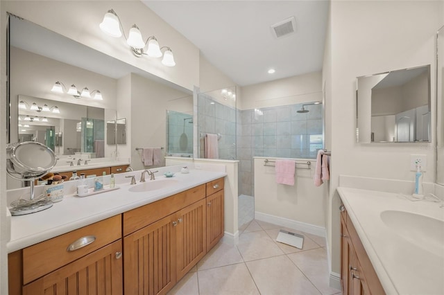 bathroom with tile patterned flooring, vanity, and tiled shower