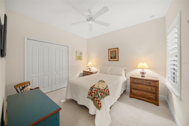 bedroom featuring light colored carpet, a closet, and ceiling fan