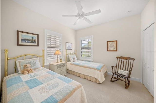 bedroom with light colored carpet, a closet, and ceiling fan