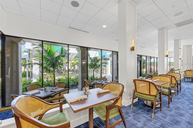 dining area with a wealth of natural light and a drop ceiling