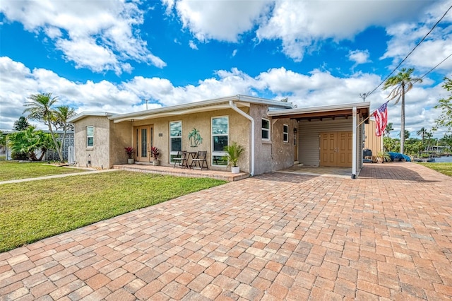 6627 Marius Rd, North Port, FL 34287 - ranch-style house with a carport, a front lawn, stucco siding, and decorative driveway