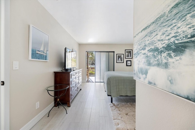 bedroom featuring access to exterior and light wood-type flooring