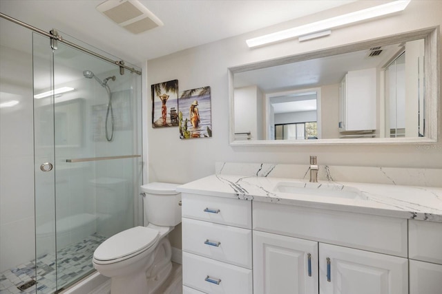 bathroom featuring vanity, toilet, and a shower with door