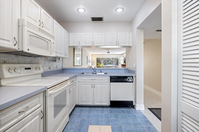 kitchen featuring sink, white appliances, white cabinetry, backsplash, and dark tile patterned flooring