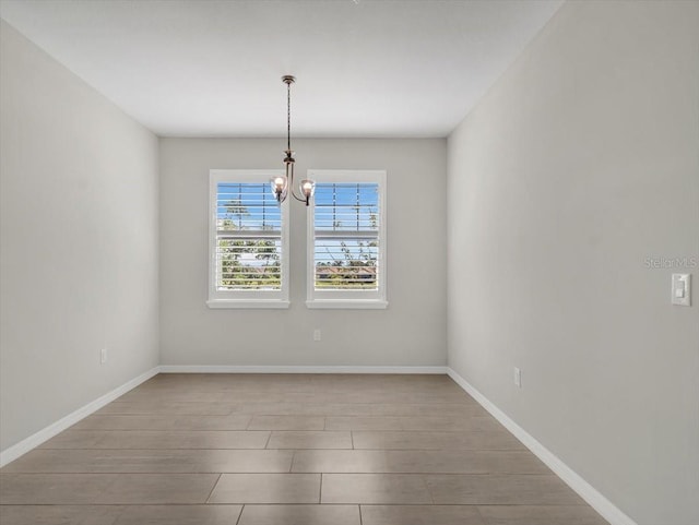 spare room with a chandelier and light hardwood / wood-style flooring