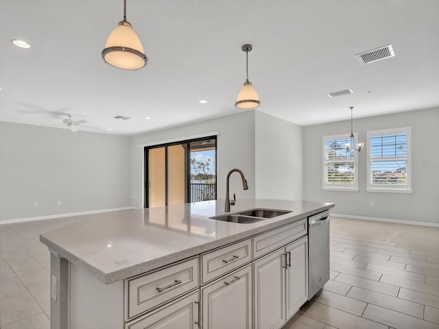 kitchen featuring stainless steel dishwasher, an island with sink, sink, and hanging light fixtures