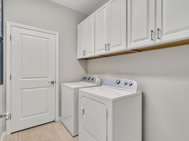 washroom featuring cabinets and washing machine and clothes dryer