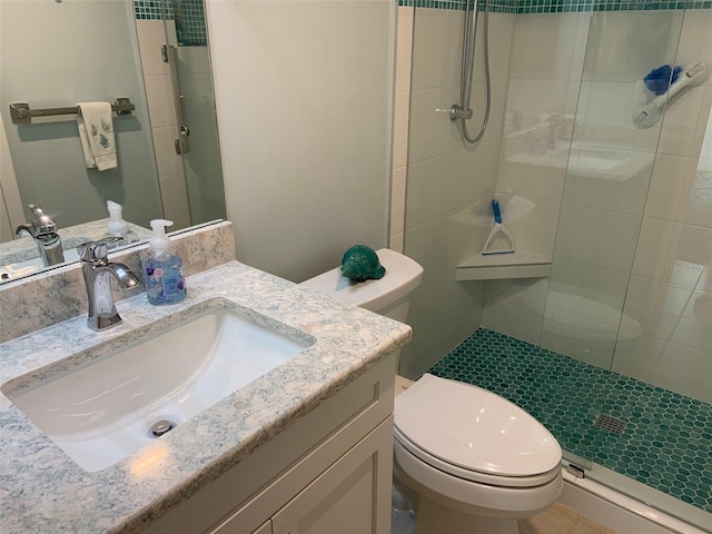 bathroom with an enclosed shower, vanity, and toilet