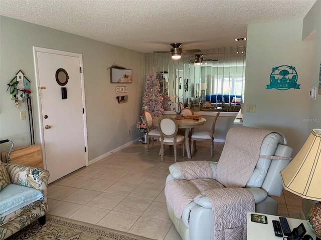 living room featuring light tile patterned floors, a textured ceiling, and ceiling fan