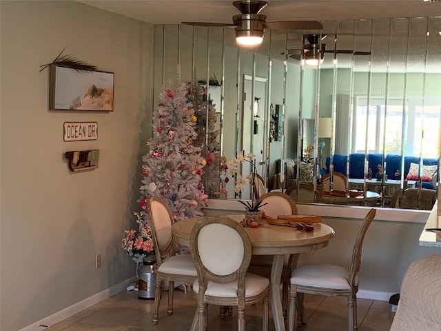 tiled dining area with ceiling fan