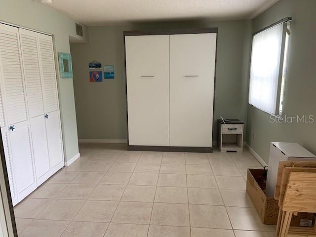 bedroom featuring light tile patterned floors, baseboards, and visible vents