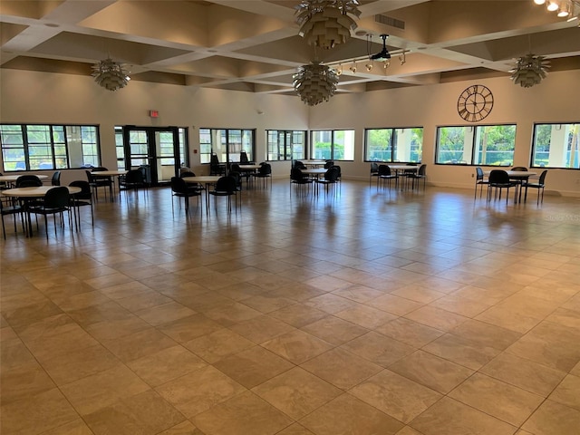 workout area with coffered ceiling, a towering ceiling, baseboards, and light tile patterned flooring