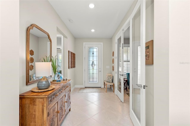 doorway to outside with plenty of natural light, light tile patterned floors, and french doors