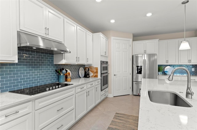 kitchen with sink, white cabinetry, light stone counters, decorative light fixtures, and stainless steel appliances