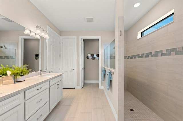 bathroom featuring vanity and tiled shower