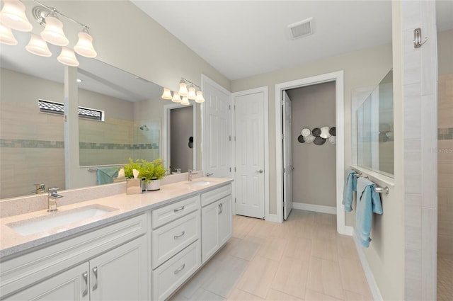 bathroom featuring a tile shower and vanity