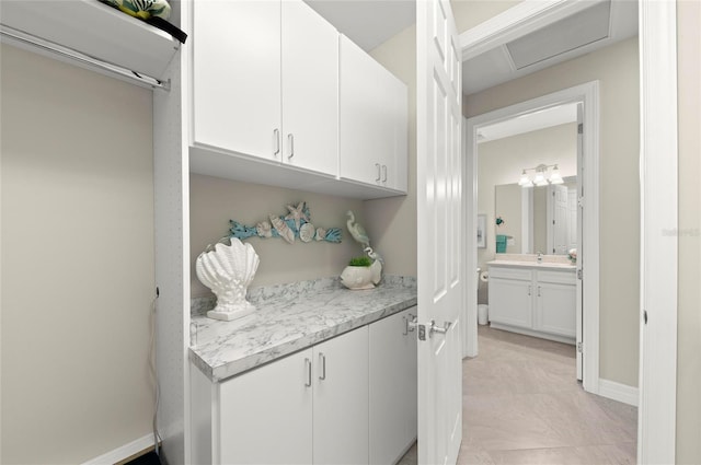 interior space featuring white cabinetry and light stone countertops