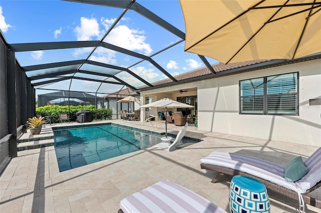 view of swimming pool with a lanai, ceiling fan, and a patio area