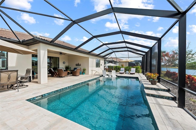 view of swimming pool featuring ceiling fan, an outdoor hangout area, glass enclosure, and a patio