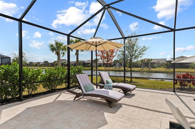 view of patio / terrace featuring a water view and glass enclosure