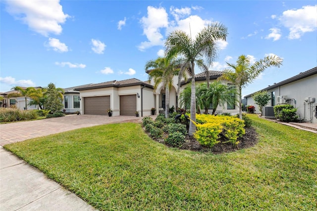 view of front of house with a garage, central AC, and a front yard