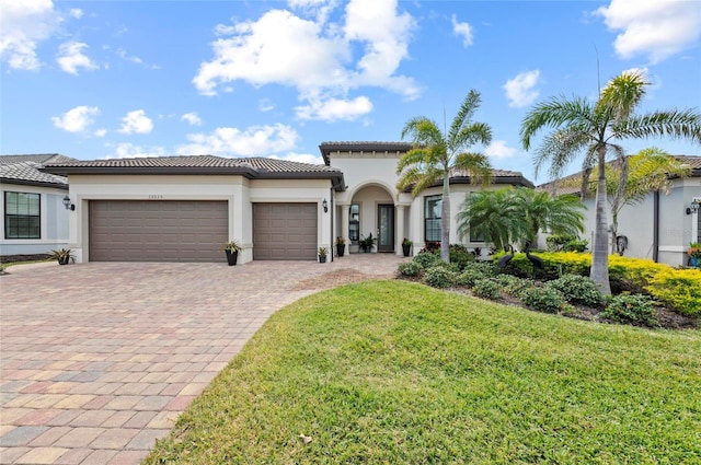 mediterranean / spanish-style house with a garage and a front lawn