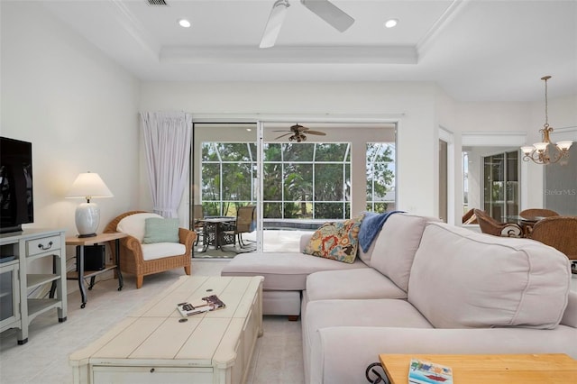 living room featuring crown molding, ceiling fan with notable chandelier, and a raised ceiling