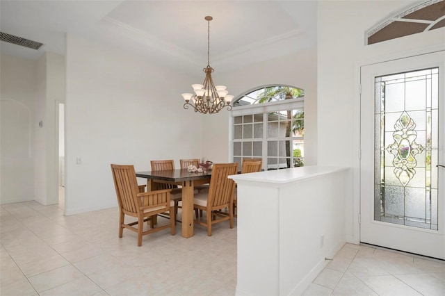 dining space featuring light tile patterned flooring, a tray ceiling, and a chandelier