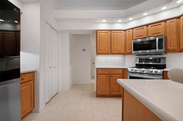 kitchen featuring tasteful backsplash, appliances with stainless steel finishes, and light tile patterned floors