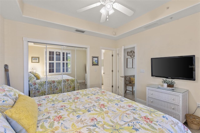 bedroom featuring a closet, ceiling fan, and a tray ceiling