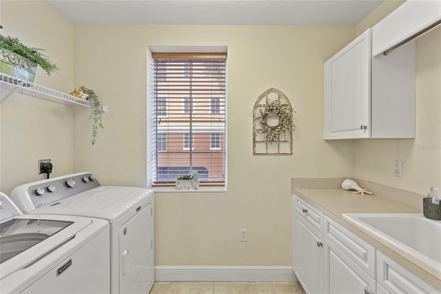 laundry room featuring cabinets, sink, light tile patterned floors, and washer and clothes dryer