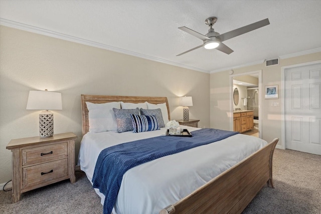 carpeted bedroom featuring crown molding, ensuite bath, and ceiling fan