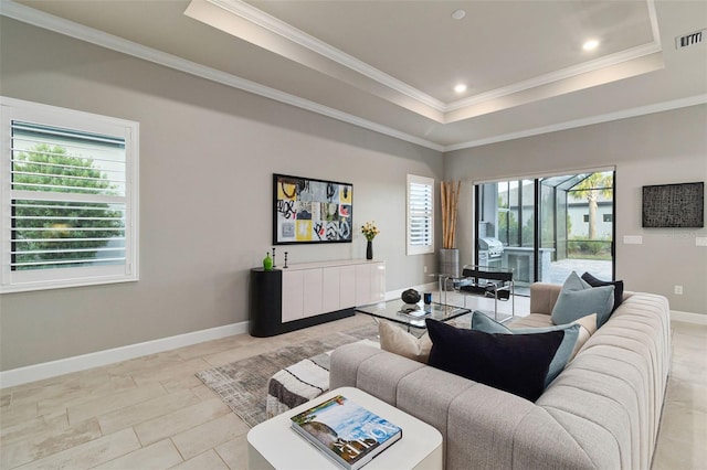 living room featuring crown molding, plenty of natural light, and a tray ceiling