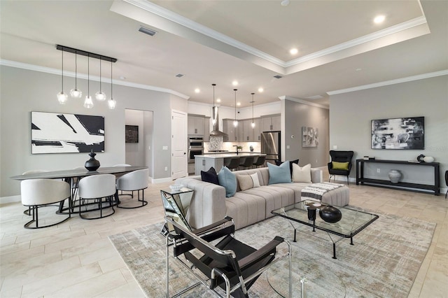 living room with ornamental molding and a tray ceiling