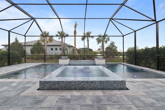 view of pool with an in ground hot tub, glass enclosure, and a patio