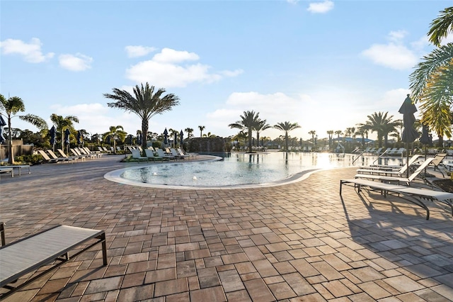 view of swimming pool featuring a patio and a water view