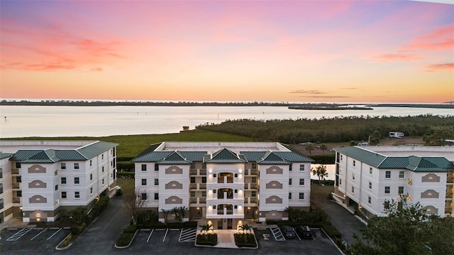 aerial view at dusk featuring a water view