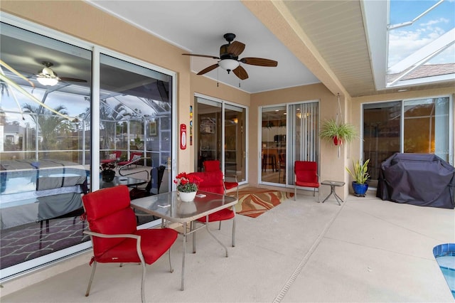 view of patio / terrace featuring ceiling fan, a grill, and glass enclosure