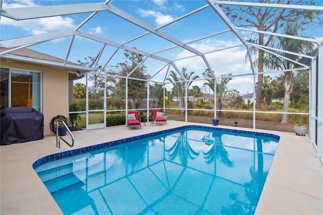 view of pool featuring a grill, glass enclosure, and a patio area