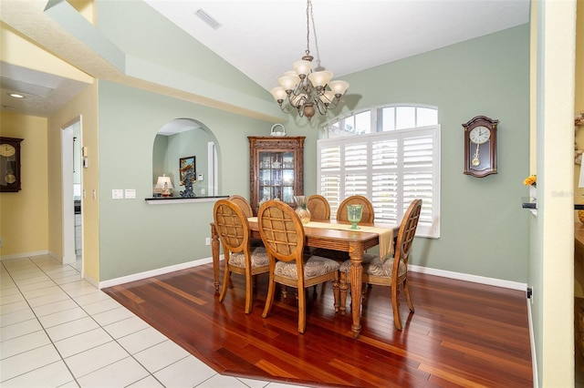 dining area featuring an inviting chandelier, light hardwood / wood-style floors, and vaulted ceiling