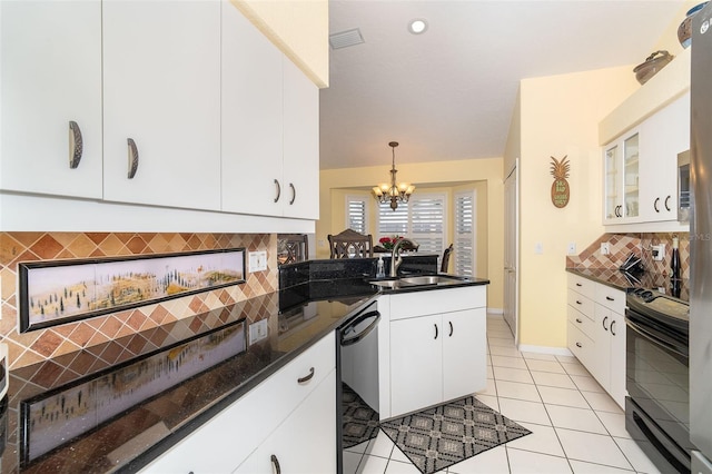 kitchen with sink, decorative light fixtures, black appliances, a fireplace, and white cabinets