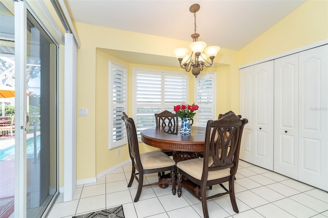 dining space featuring lofted ceiling, light tile patterned floors, a wealth of natural light, and a chandelier