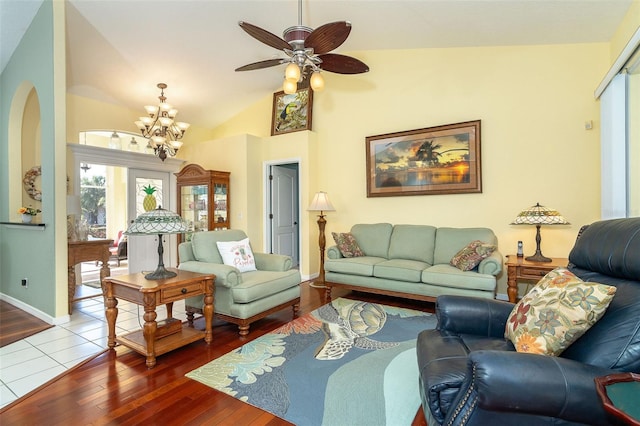 living room featuring vaulted ceiling, ceiling fan with notable chandelier, and hardwood / wood-style floors