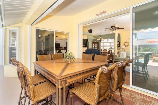 dining space with vaulted ceiling and ceiling fan with notable chandelier